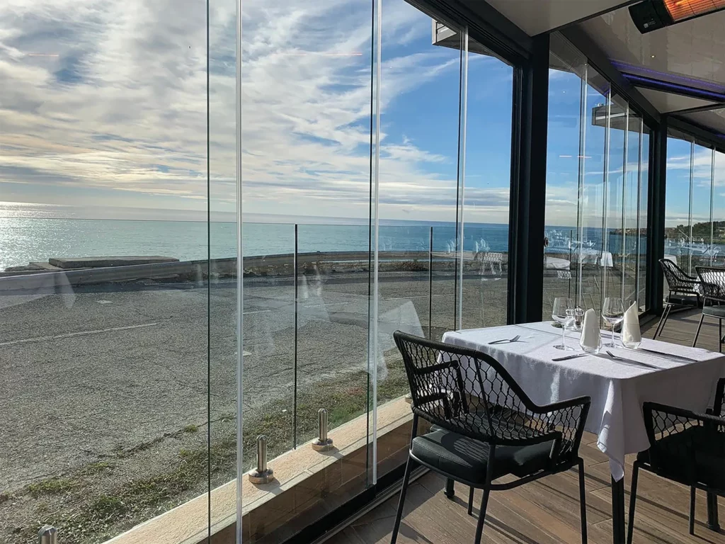 pergola bioclimatique aluminium avec rideaux de verres coulissants - terrasse de restaurant